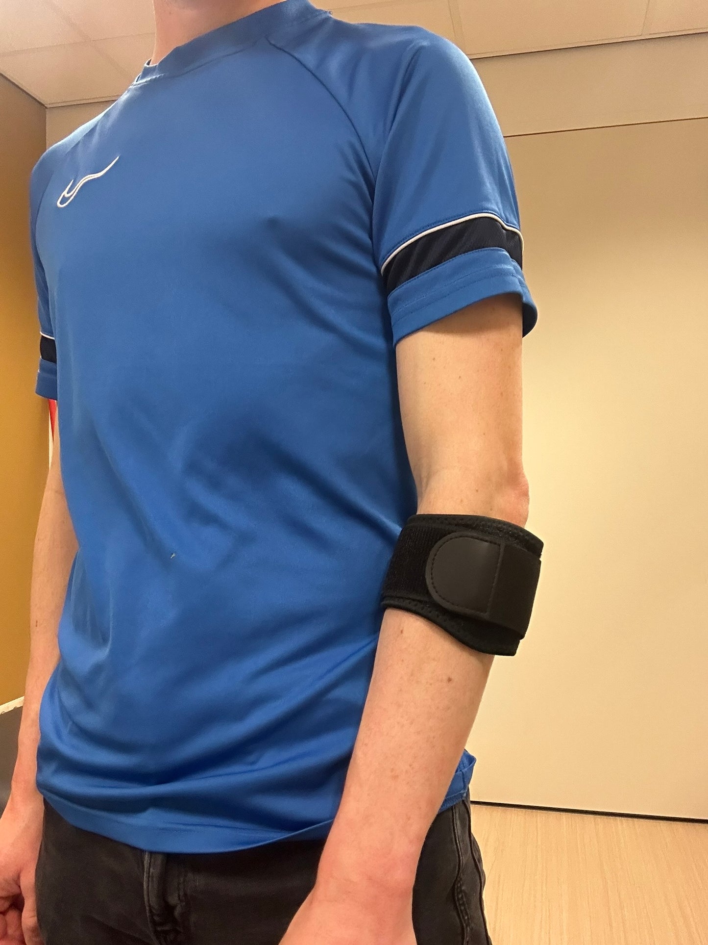 Een fysiotherapeut die een patiënt met een tennisarm behandelt door gerichte massage en het toepassen van een manuele techniek op de onderarmspieren.