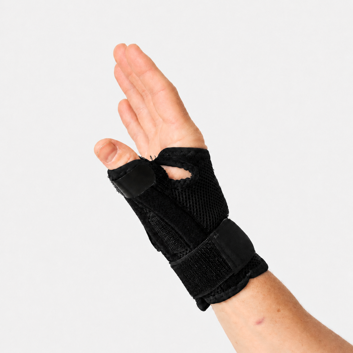 Zwarte duimbrace gedragen om hand en pols met verstelbare banden voor ondersteuning van de duim.