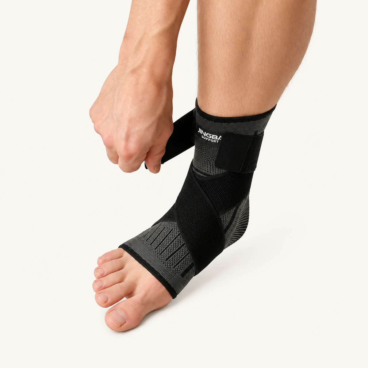 Hand die de verstelbare band van een compressie enkelbrace aantrekt voor extra ondersteuning