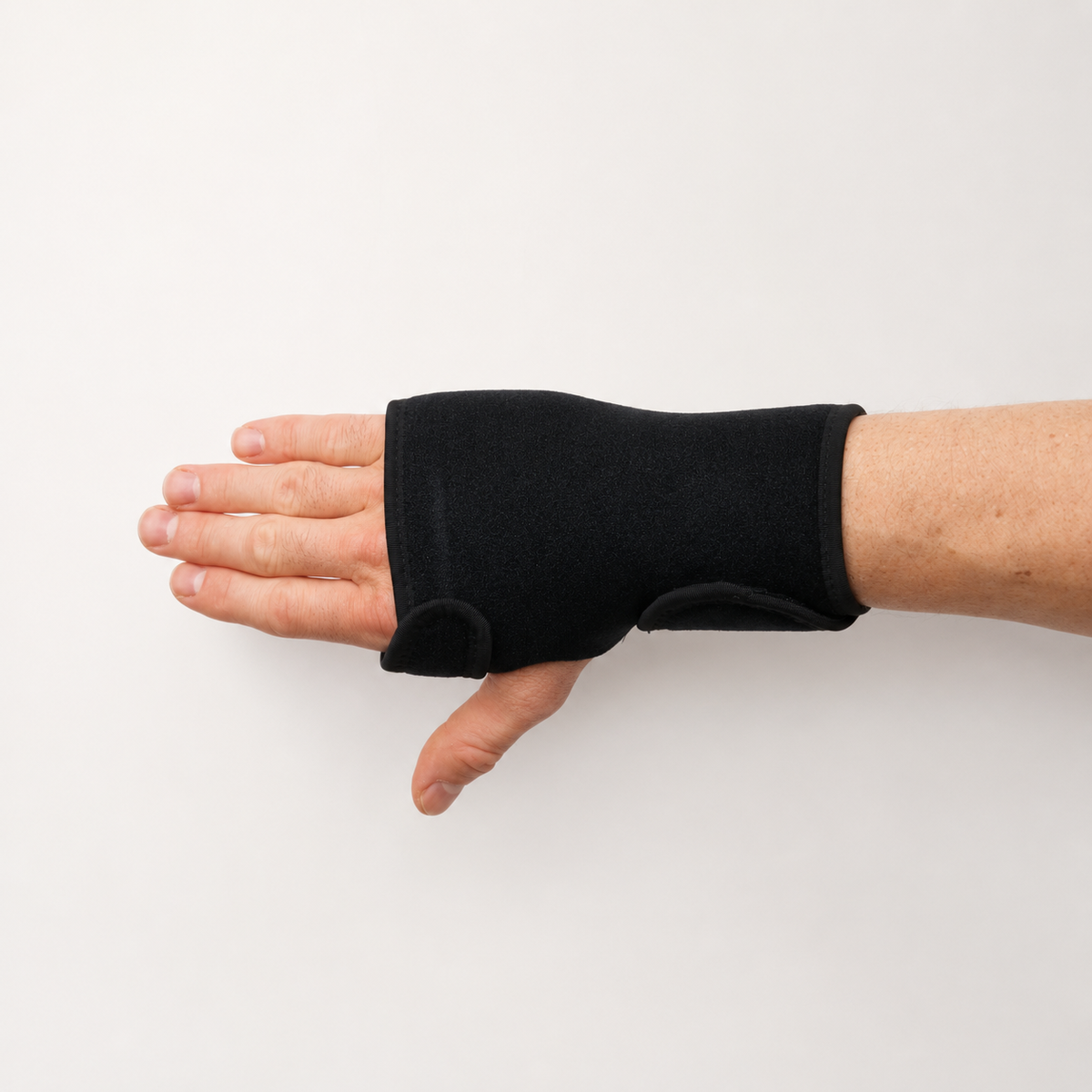 Zwarte handbrace voor een gebroken middenhandsbeentje met ondersteuning rond hand, duim en pols