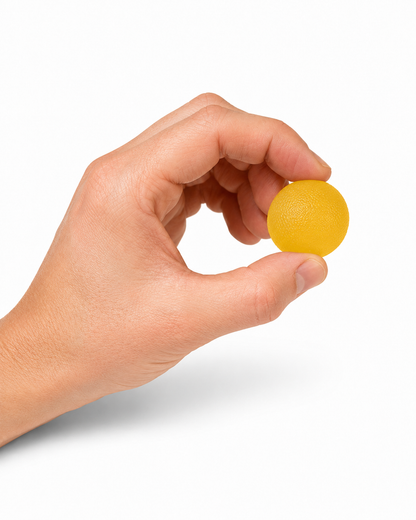 Hand gebruikt een gele gel knijpbal voor het trainen van handkracht, mobiliteit en coördinatie.