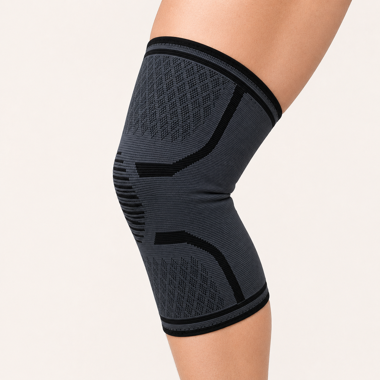 Grijze compressie kniebrace gedragen om licht gebogen knie vanuit schuin zijaanzicht