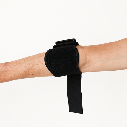 Zwarte tennisarm brace gedragen op de onderarm in schuine hoek met zicht op de drukzone