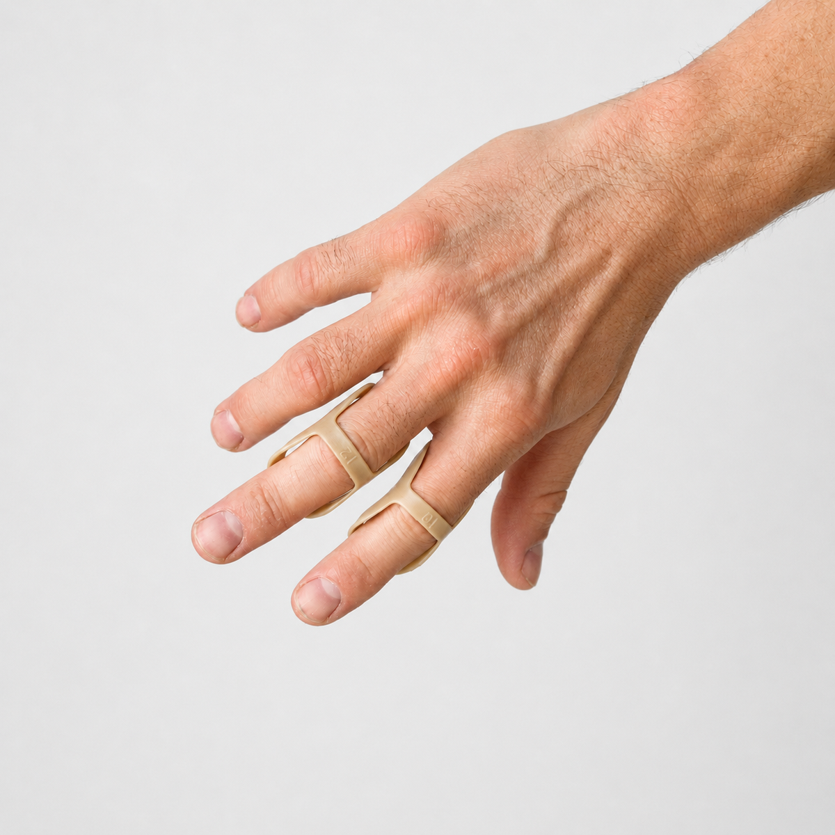 Twee beige vinger splints gedragen aan de vingers, gezien vanaf de achterzijde van de hand.