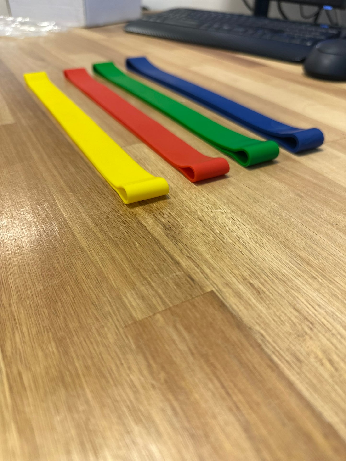 Gele, rode, groene en blauwe weerstand banden voor krachttraining in verschillende gewichten.